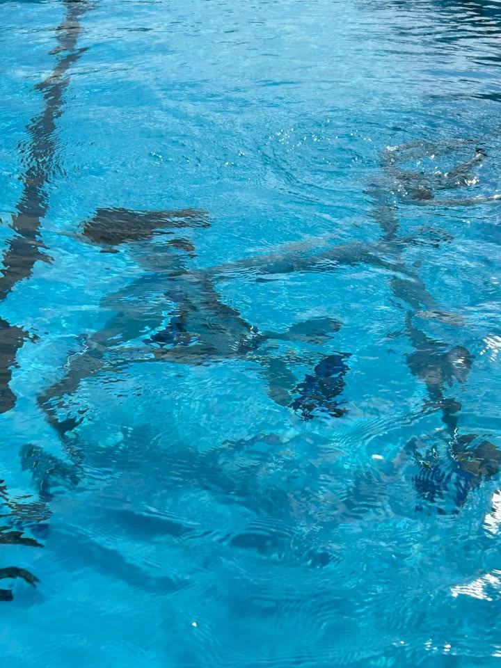 An underwater view of an aqua bike beneath the bright blue surface