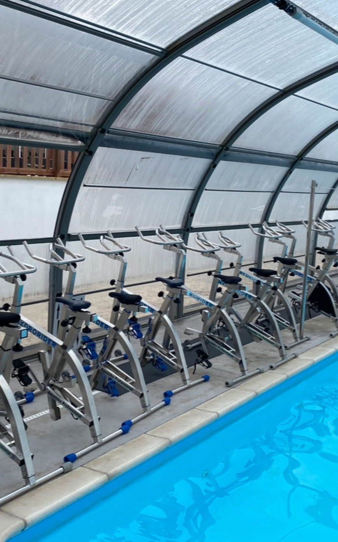 A row of Hydrorider aqua bikes under a pool dome, ready to go into the water